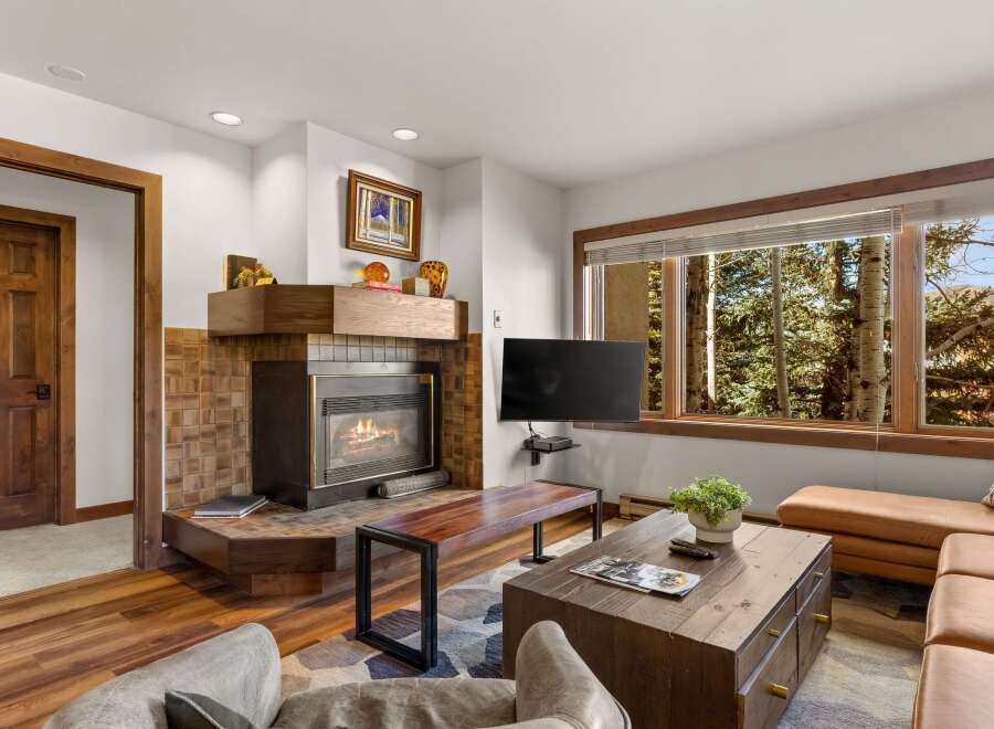 Cozy living room featuring a warm fireplace with a tiled surround and a wooden mantel.
