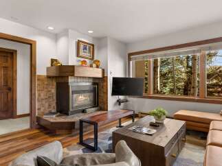 Cozy living room featuring a warm fireplace with a tiled surround and a wooden mantel.