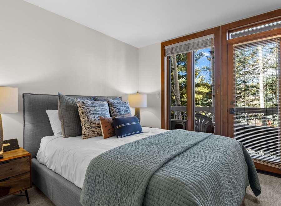Experience ultimate comfort in this beautifully appointed bedroom, featuring a plush king-size bed adorned with decorative pillows and a cozy quilted throw.