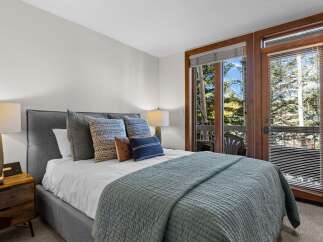 Experience ultimate comfort in this beautifully appointed bedroom, featuring a plush king-size bed adorned with decorative pillows and a cozy quilted throw.