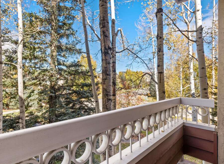 Enjoy the crisp mountain air from this charming balcony, offering picturesque views of aspen and pine trees in their autumn splendor.
