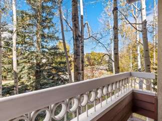 Enjoy the crisp mountain air from this charming balcony, offering picturesque views of aspen and pine trees in their autumn splendor.
