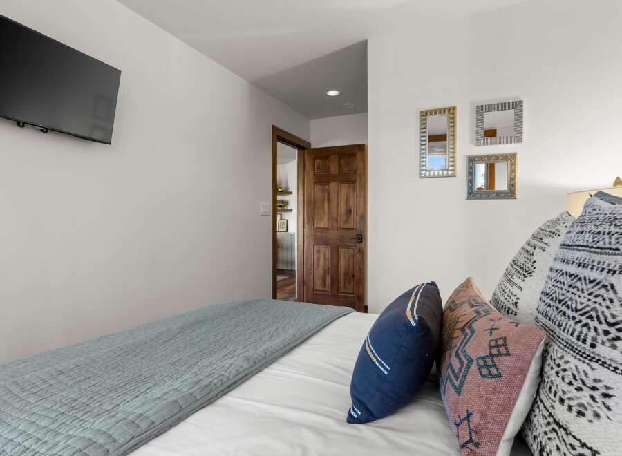 This bedroom offers a comfortable and stylish retreat, featuring a plush bed adorned with decorative pillows and a calming blue quilt.