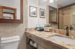 This luxurious bathroom features a spacious vanity with a granite countertop and a modern undermount sink.
