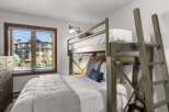 This bedroom features a space-saving bunk bed with a twin-over-twin configuration, perfect for maximizing sleeping arrangements.