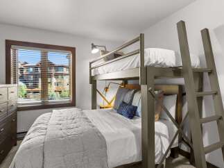 This bedroom features a space-saving bunk bed with a twin-over-twin configuration, perfect for maximizing sleeping arrangements.