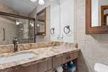 This bathroom features a granite countertop with an undermount sink and a bronze faucet.