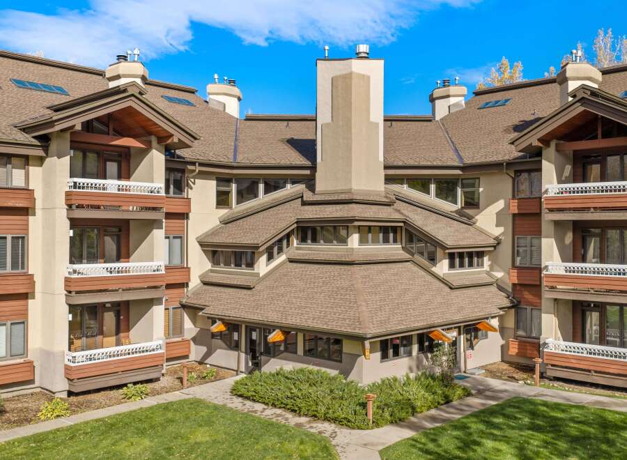 Experience the charm of this multi-story building featuring a unique, multi-faceted roofline and prominent chimneys.
