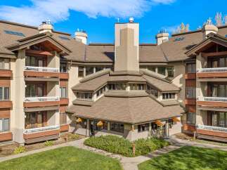 Experience the charm of this multi-story building featuring a unique, multi-faceted roofline and prominent chimneys.