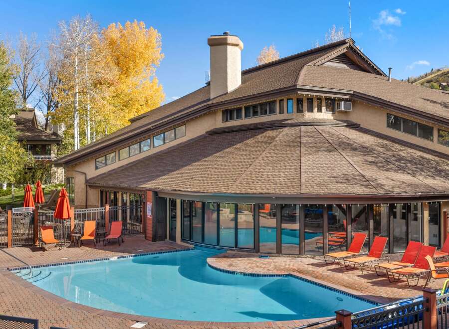 Enjoy a refreshing dip in the sparkling blue pool, surrounded by a beautifully paved patio and comfortable lounge chairs.