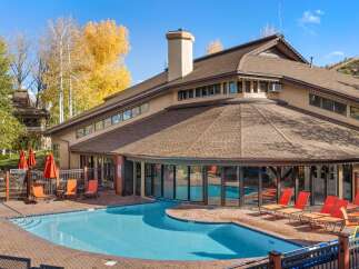 Enjoy a refreshing dip in the sparkling blue pool, surrounded by a beautifully paved patio and comfortable lounge chairs.