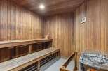 Experience ultimate relaxation in this luxurious wooden sauna, featuring comfortable tiered seating and a modern electric heater.