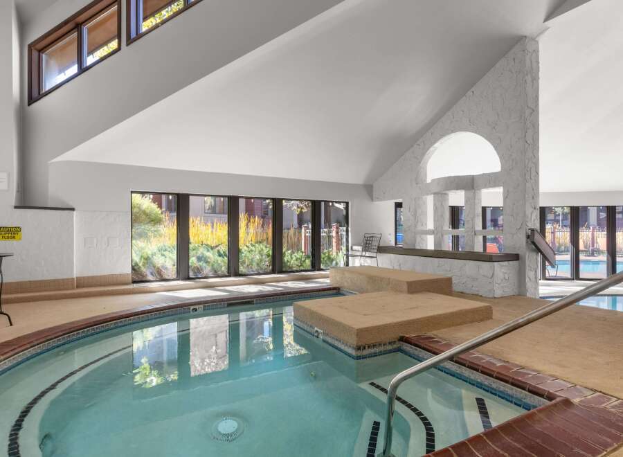 Indulge in relaxation in this indoor spa, featuring a spacious hot tub with built-in seating and a soothing ambiance.