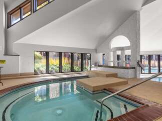 Indulge in relaxation in this indoor spa, featuring a spacious hot tub with built-in seating and a soothing ambiance.