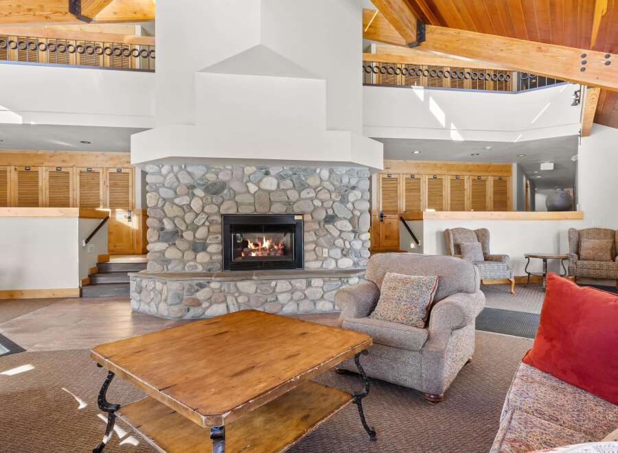 Experience rustic charm in this spacious living area, featuring a magnificent floor-to-ceiling stone fireplace that serves as the heart of the home.