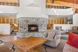 Experience rustic charm in this spacious living area, featuring a magnificent floor-to-ceiling stone fireplace that serves as the heart of the home.