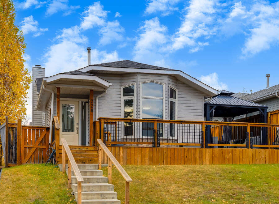 This charming home features a spacious wooden deck perfect for outdoor entertaining, complete with a covered gazebo.