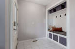 This entryway features a white door with a glass panel and a modern lock, leading into a space with light gray walls and tiled flooring.