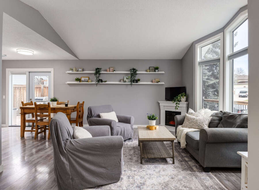 Step into this inviting living space featuring a cozy fireplace and large windows that flood the room with natural light.