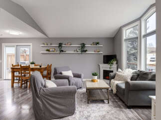 Step into this inviting living space featuring a cozy fireplace and large windows that flood the room with natural light.