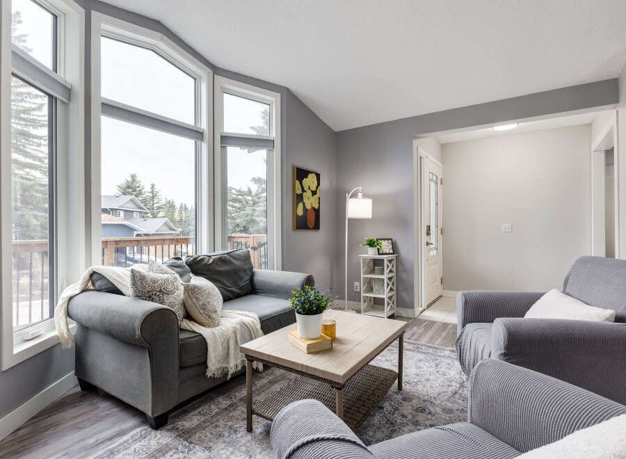 Step into this inviting living room, bathed in natural light from the expansive bay windows offering scenic views.