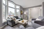 Step into this inviting living room, bathed in natural light from the expansive bay windows offering scenic views.