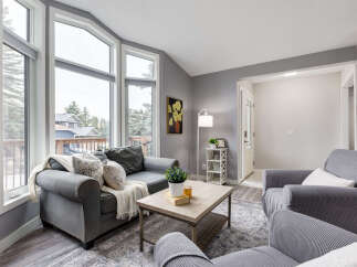 Step into this inviting living room, bathed in natural light from the expansive bay windows offering scenic views.