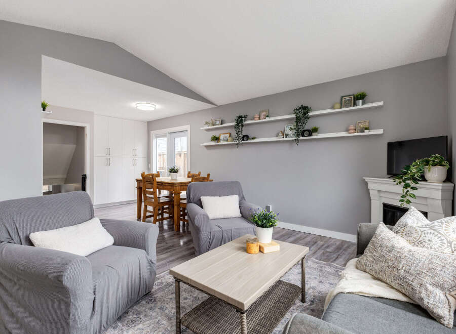 Step into this inviting living space featuring comfortable gray seating arrangements, a stylish coffee table, and a charming dining area.