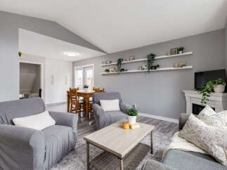 Step into this inviting living space featuring comfortable gray seating arrangements, a stylish coffee table, and a charming dining area.