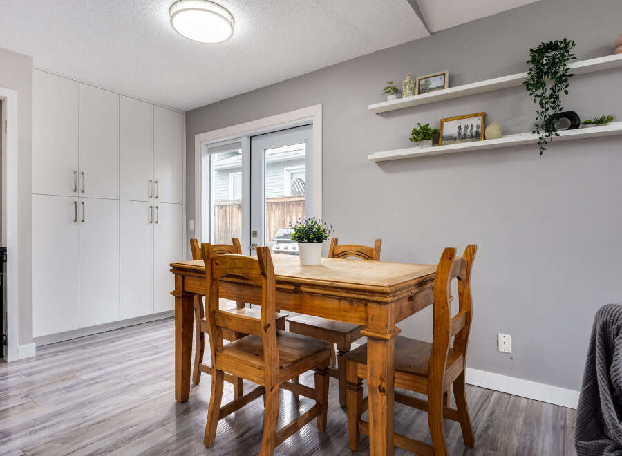 This dining area features a rustic wooden table with four chairs, perfect for intimate family meals.