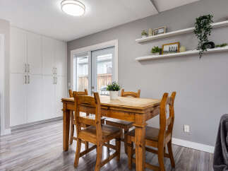 This dining area features a rustic wooden table with four chairs, perfect for intimate family meals.