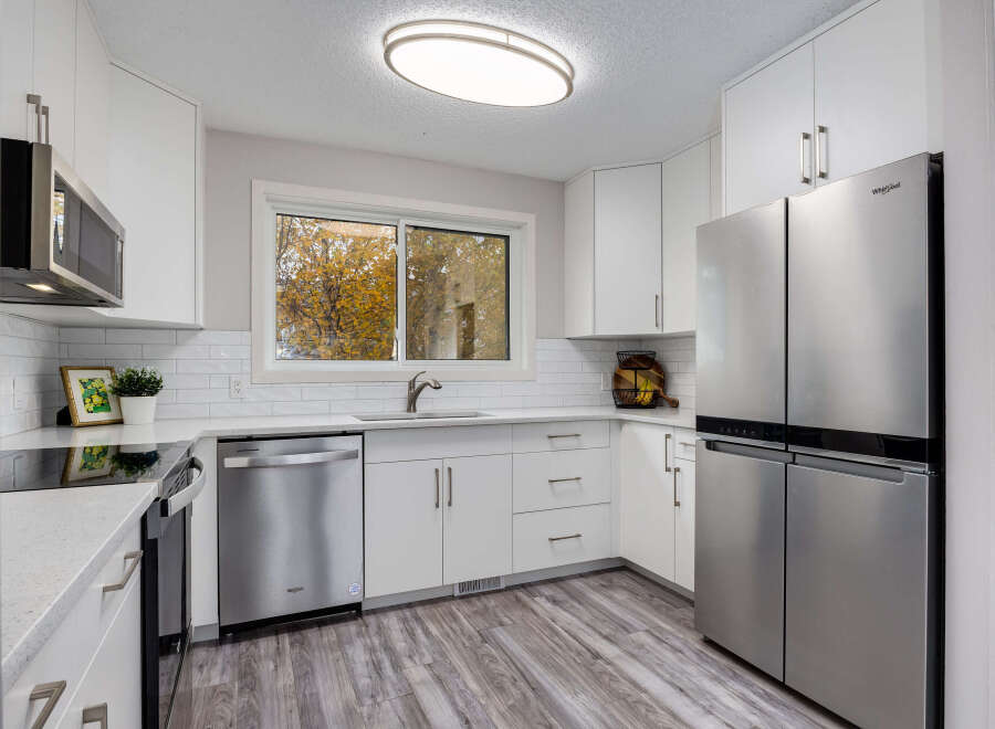 Step into this beautifully updated kitchen, featuring sleek stainless steel appliances including a French door refrigerator and a modern microwave.