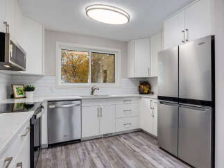 Step into this beautifully updated kitchen, featuring sleek stainless steel appliances including a French door refrigerator and a modern microwave.