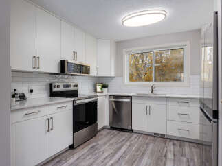 This modern kitchen boasts sleek white cabinetry and a stylish subway tile backsplash, creating a bright and airy atmosphere.