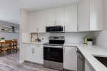 This modern kitchen boasts sleek white cabinetry and a stainless steel range, complemented by a subway tile backsplash.