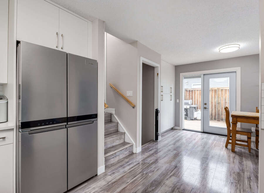 Step into this beautifully renovated kitchen featuring a sleek stainless steel refrigerator and ample cabinet space.