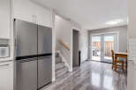 Step into this beautifully renovated kitchen featuring a sleek stainless steel refrigerator and ample cabinet space.