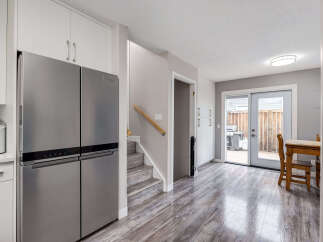 Step into this beautifully renovated kitchen featuring a sleek stainless steel refrigerator and ample cabinet space.