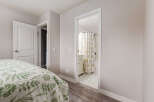 Step into a serene bedroom featuring a comfortable bed adorned with a charming floral duvet cover.