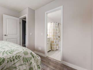Step into a serene bedroom featuring a comfortable bed adorned with a charming floral duvet cover.