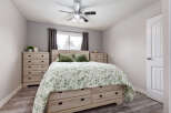 This charming bedroom features a spacious queen-size bed with a beautiful green floral comforter and plush green pillows.