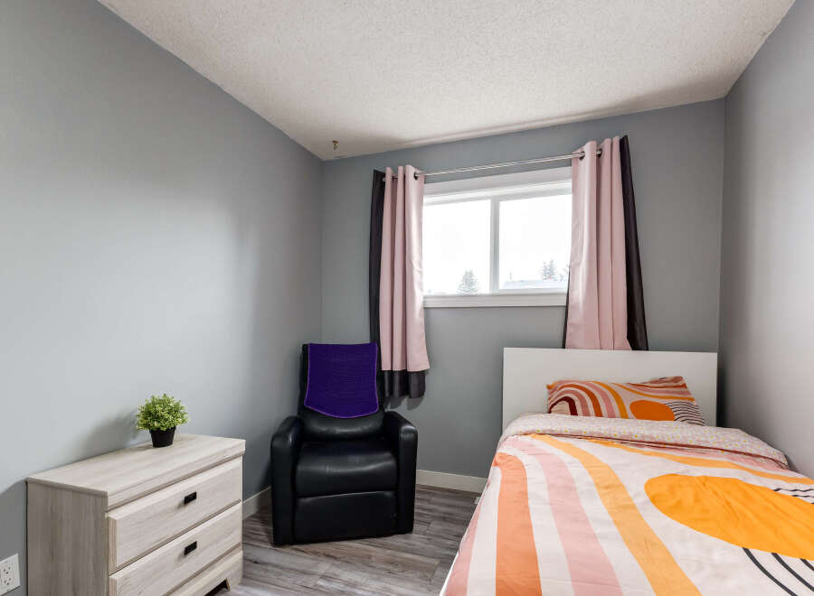 This cozy bedroom features a comfortable bed with vibrant, patterned bedding and a matching pillow.