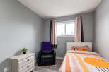 This cozy bedroom features a comfortable bed with vibrant, patterned bedding and a matching pillow.