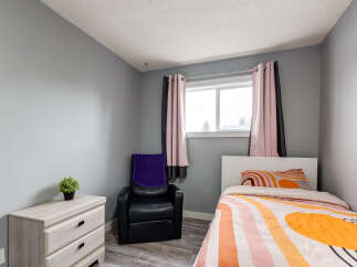 This cozy bedroom features a comfortable bed with vibrant, patterned bedding and a matching pillow.