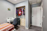 This bedroom features a convenient white desk with drawers and shelving, perfect for studying or working from home.