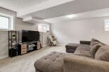 This basement living room features a large, comfortable sectional sofa perfect for family movie nights.