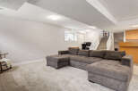 This spacious basement living area features a large, comfortable sectional sofa perfect for family gatherings or relaxing evenings.