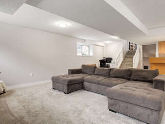 This spacious basement living area features a large, comfortable sectional sofa perfect for family gatherings or relaxing evenings.