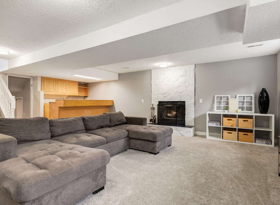 This spacious basement living area features a large, comfortable sectional sofa perfect for family gatherings.