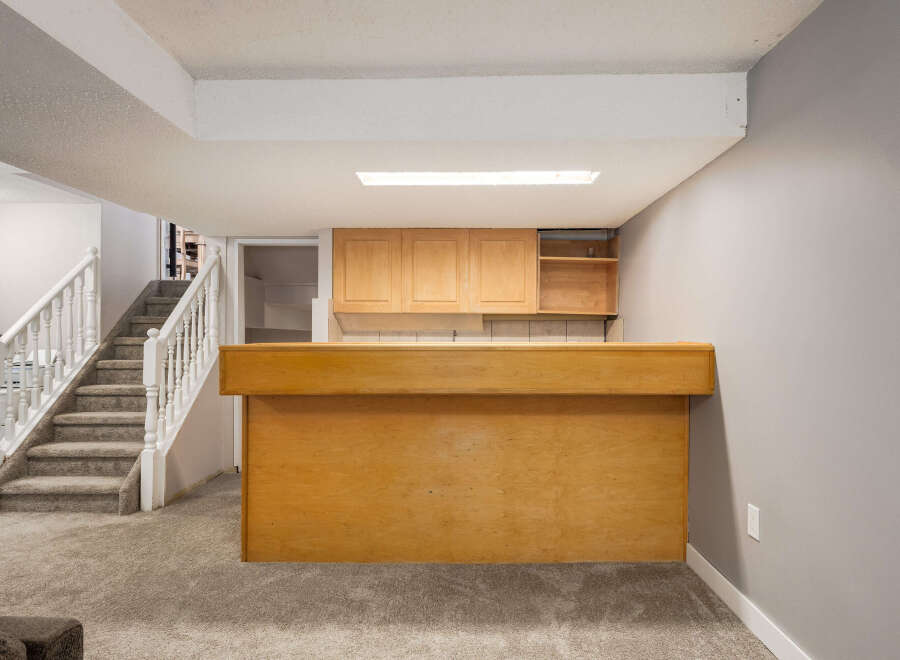 Step into this inviting basement featuring a spacious bar area perfect for entertaining.